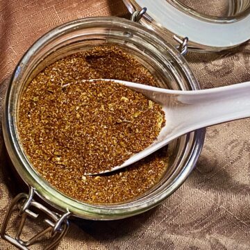 No-Salt Taco Seasoning in an open storage container with a spoon.